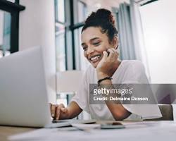 Image of person working on a laptop from home, smiling and making money