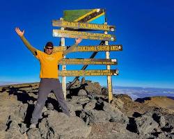 Image of climber on Kilimanjaro summit, sunrise over Africa