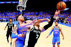 Oklahoma City center Isaiah Hartenstein (55) fouls San Antonio center Luke Kornet (7) during the first half on Monday in Oklahoma City.