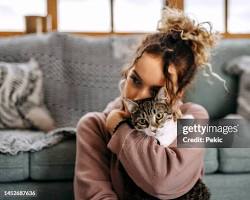 person cuddling with a cushion with their pet's photo on itの画像