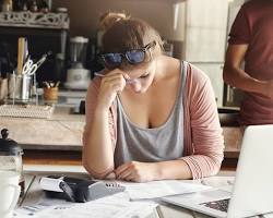 Image of someone looking stressed while holding a calculator
