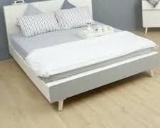 Gambar Kamar tidur minimalis dengan tempat tidur platform berbahan kayu solid dan sprei berwarna putih.