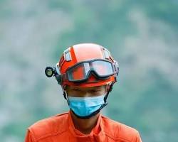 Image of person holding a helmet during an earthquake