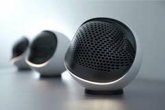 Modern wireless spherical speakers standing in line on white