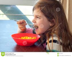 Young girl eating macaroni and cheese - young-girl-eating-macaroni-cheese-26274234