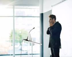 businessperson standing in front of a whiteboard with a bunch of business jokes written on it.