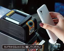 スマートフォンをバスの決済リーダーにかざしている様子の画像