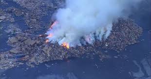 Smoke from Waste Management recycling yard fire spills over Interstate 70 and Colorado Boulevard