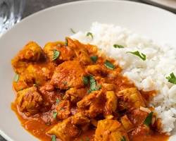 Image of Chicken Tikka Masala served alongside fluffy basmati rice and warm naan bread