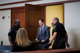 Husband Denies Plot in Double Murder Trial, Calling Accusations ‘Crazy’