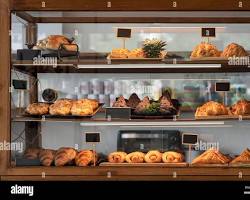 Freshly baked bread and pastries displayed at a cafeの画像