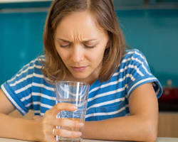 Image of someone drinking tap water with a satisfied expression
