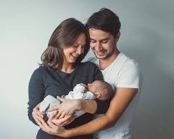 Image of happy couple holding a baby