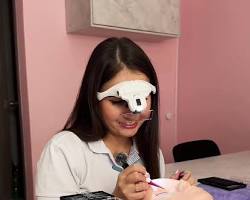 Imagen de Una esteticista usando las gafas lupa para aplicar extensiones de pestañas