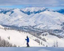 Image of Sun Valley Resort, Idaho with skiers on the slopes and a classic ski lodge