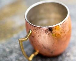 Image of person drinking water from a copper cup