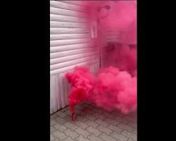 Imagine cu Persoană ținând o fumigena roz