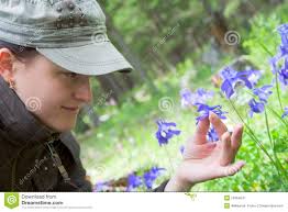 Young woman holding a blue flower in the hands of - young-woman-holding-blue-flower-hands-19384047