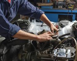 Image of mechanic working on a car engine