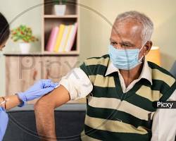 Image of nurse giving an injection to an elderly patient at home