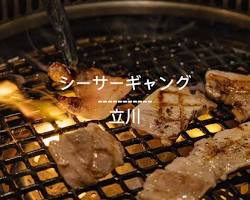 焼き鳥ギャング沖縄の開放的なテラス席と食事を楽しむ家族の画像
