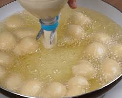 Colocando a massa no óleo para bolinho de chuva