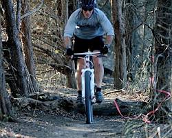 Image of mountain biker successfully clearing a technical obstacle