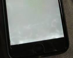 Image of phone with a cracked screen submerged in water