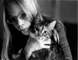 Young woman holding her cat: The cat is looking at the camera while the girl - p9-b