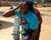 Image of woman collecting water from a handpump in Malawi