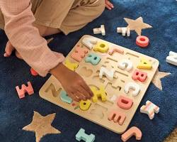 child playing with an alphabet wood puzzle的图片