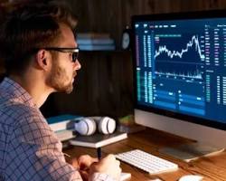 Image of person looking at a computer screen with a bitcoin chart