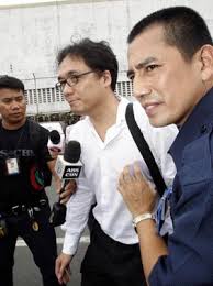 Interpol Division Chief Inspector Li Kwai-wah is escorted by aviation security to a waiting vehicle after he was held at Ninoy Aquino International Airport ... - 0013729e4abe0deaa1b216