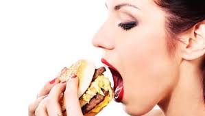 Burgers, Fries, Statins? Should Fast Food Chains Serve up Cholestorol Drugs? close-up portrait of young beautiful woman is eating big mac isolated on white ... - Fast_Food_Burger