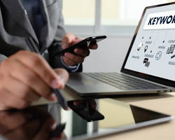 person using keyword research tools on a computer resmi