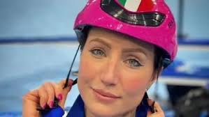 Female athlete in pink helmet with Italian flag adjusting strap