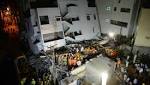 Three-storey building tilts falls, worker