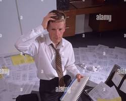 Image of confused person surrounded by paperwork