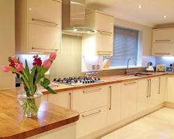 تصویر kitchen with cream cabinets and a wooden countertop