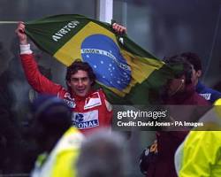 Image of Ayrton Senna celebrating victory with a Brazilian flag