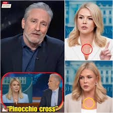 KAROLINE LEAVITT HUMILIATED BY JON STEWART — AND JUST DAYS LATER, SHE TOOK OFF HER CROSS NECKLACE. She finally ditched her signature necklace this week—right after Stewart torched her live on The
