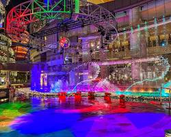 couple watching the fountain show at Canal City Hakata, with colorful lights illuminating the water.の画像