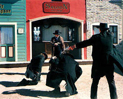 Image of dramatic painting depicting the Gunfight at the O.K. Corral, with smoke billowing from guns and men falling to the ground