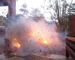 Imagine cu person lighting a Dum Bum Red Flame Cracker in a safe and controlled environment