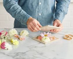 person cleaning preserved flowers with a damp cloth