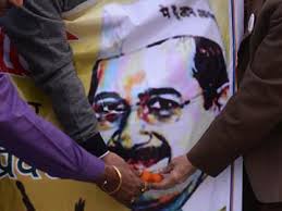 This engineer came from London to work for Aam Aadmi Party campaign. Supporters of the Aam Aadmi Party pose as they offer sweets to a poster bearing the ... - kejriwal_poster_AFP_360x270