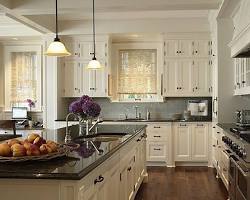 تصویر kitchen with cream cabinets and black countertops