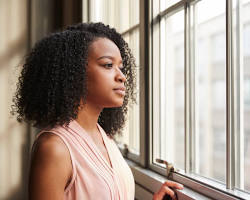thoughtful woman looking out a windowの画像