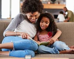 صورة parent reading a book to their child