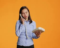 Person making a call from smartphone to a landlineの画像